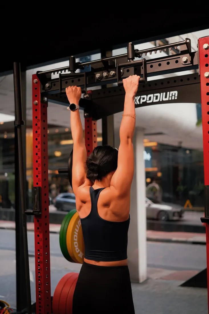Athlete training on the rack at the PGP Studio, with the Ploenchit street visible through the window